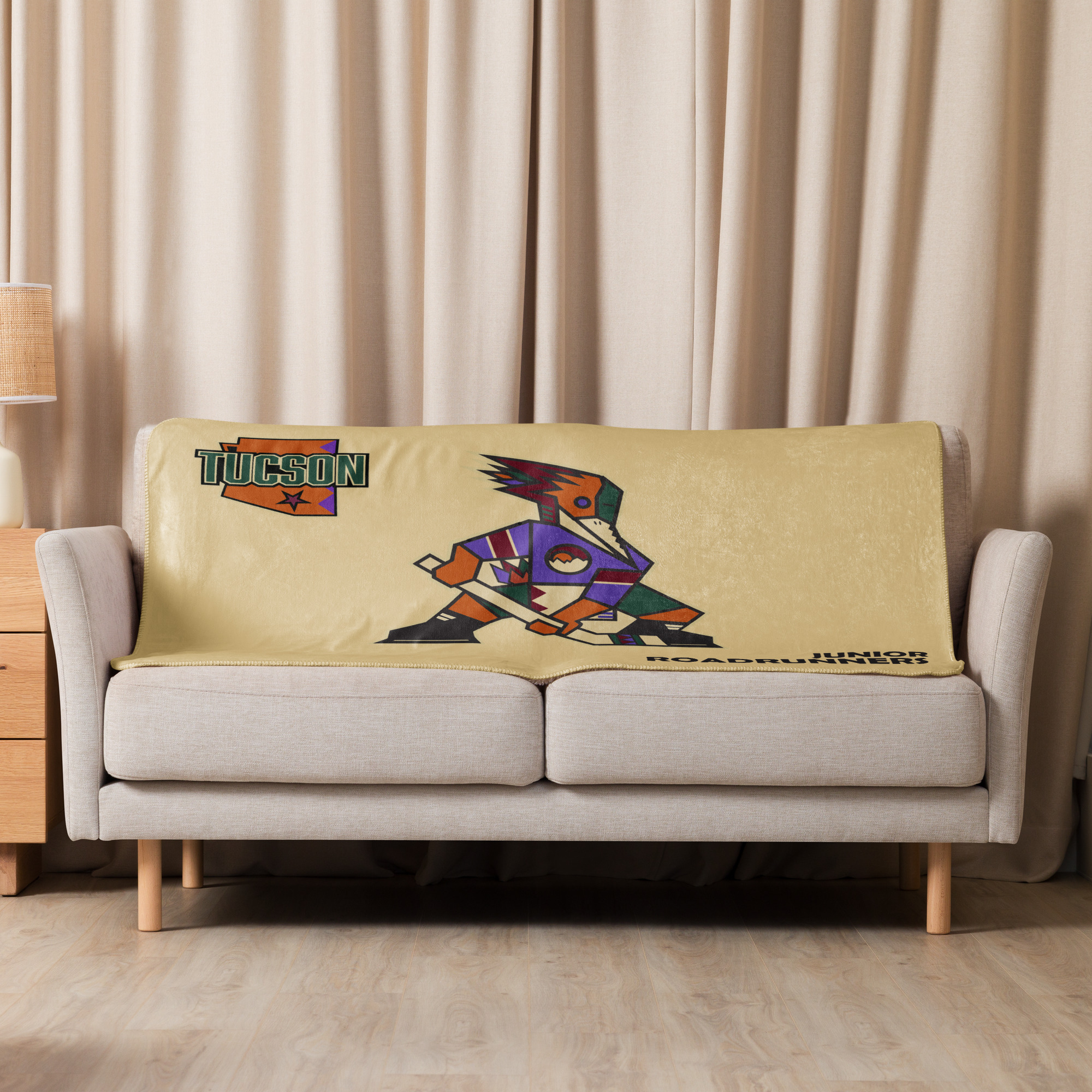 Sand Tucson Junior Roadrunners Kachina sherpa blanket displayed on a couch in the 37 x 57 size